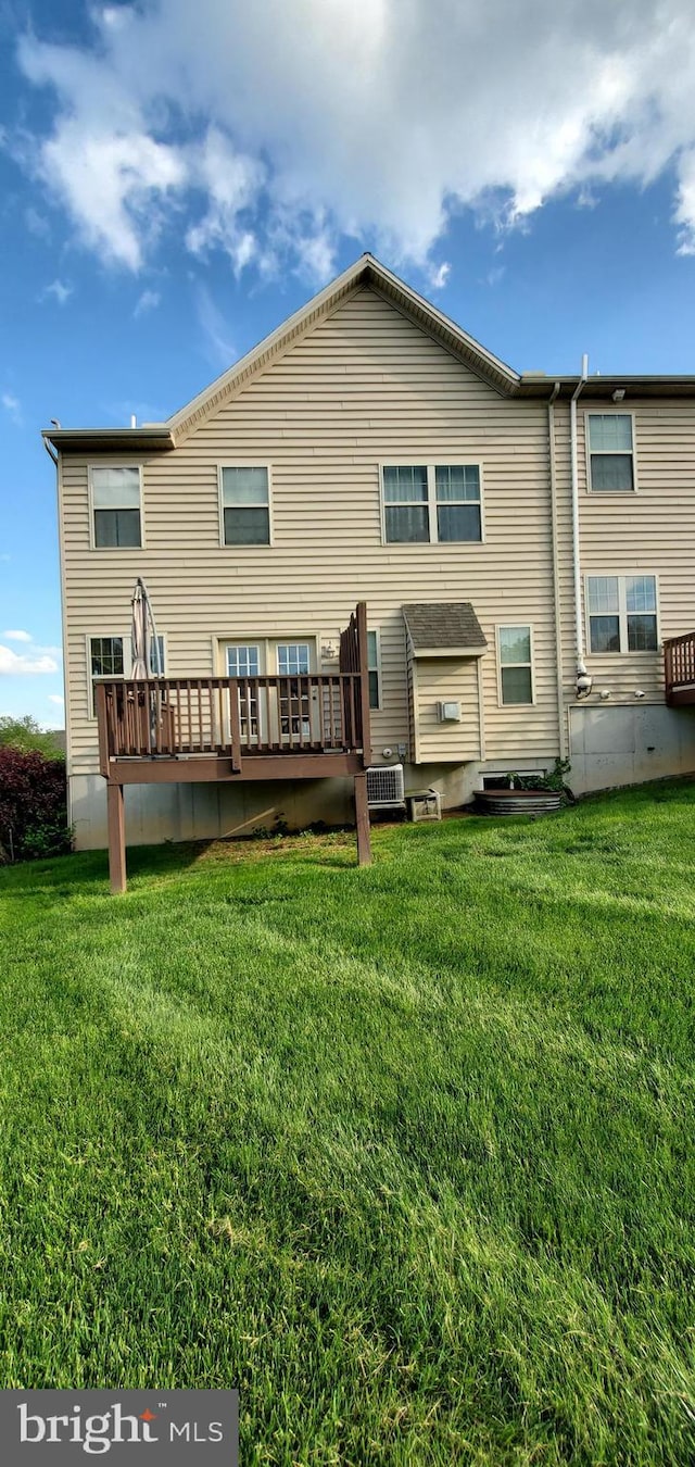 back of house with a lawn and a deck