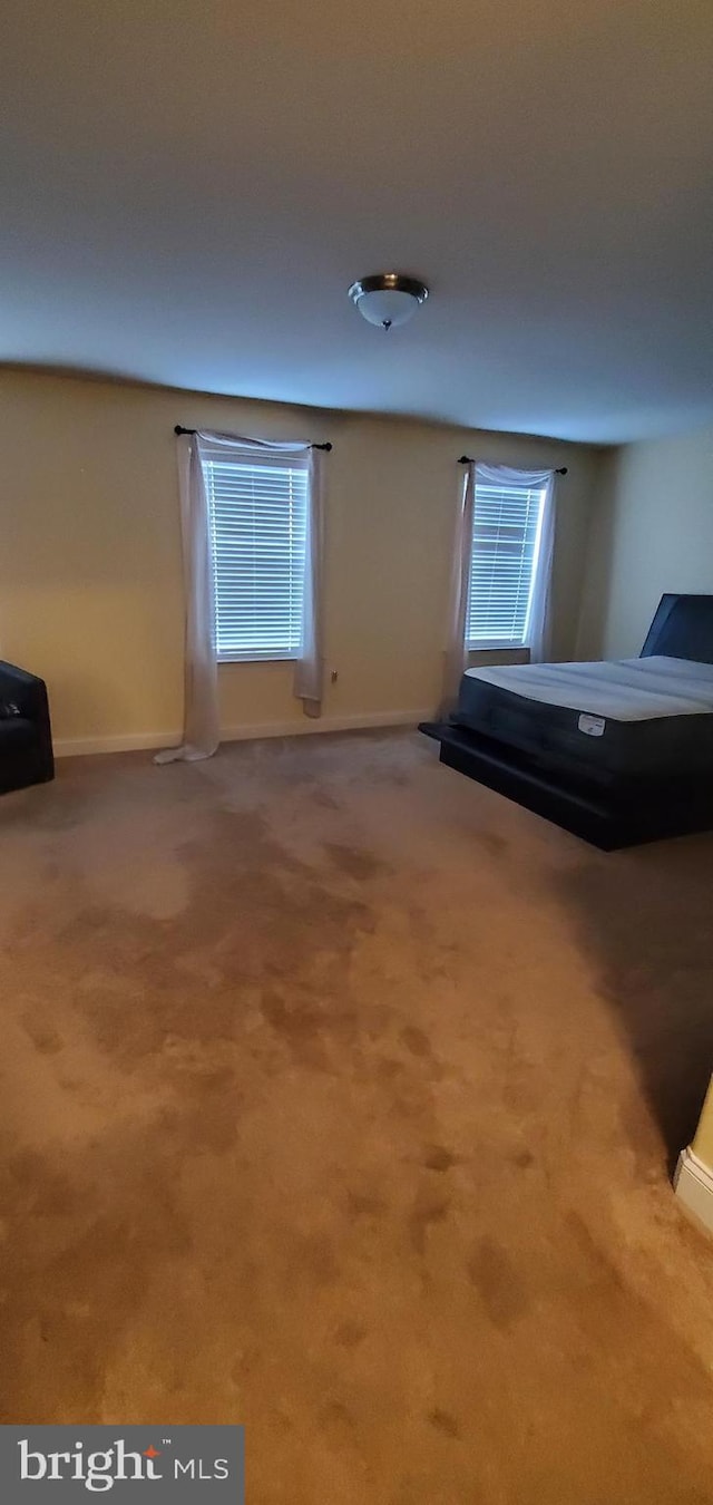 unfurnished bedroom with baseboards and carpet