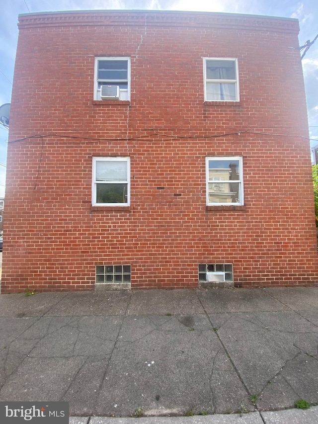 view of home's exterior with brick siding and a patio