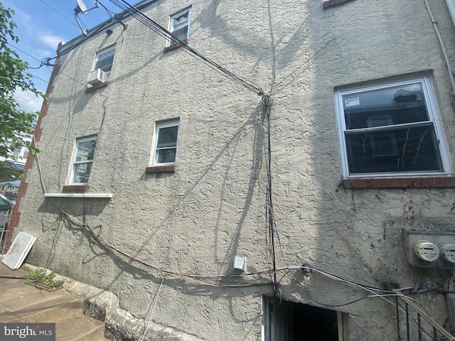view of side of home featuring stucco siding and cooling unit