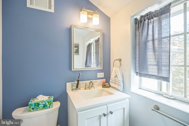 bathroom featuring vaulted ceiling, toilet, and vanity