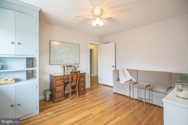 home office with light wood finished floors and ceiling fan