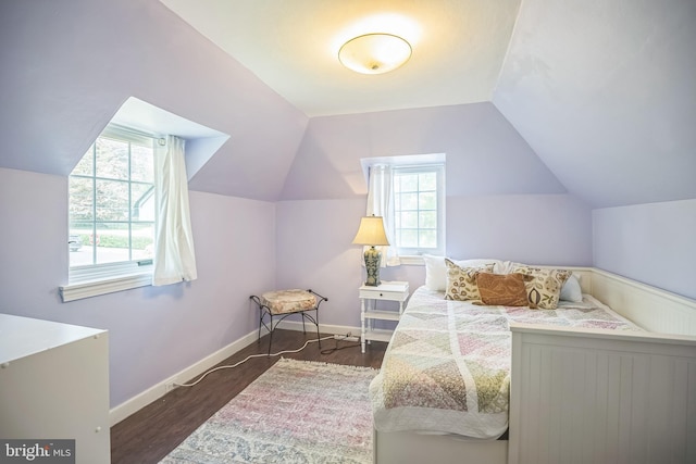 bedroom with lofted ceiling, wood finished floors, and baseboards