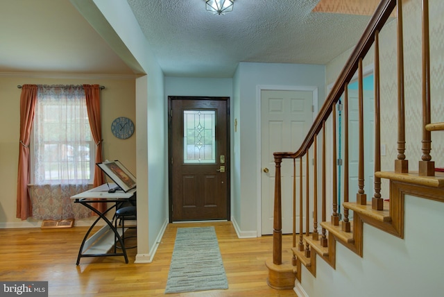 8406 Cedar Ln, King George, VA 22485 - entrance foyer featuring light wood-type flooring, stairs, a textured ceiling, and baseboards