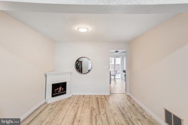 384 Bolton Rd, East Windsor, NJ 08520 - unfurnished living room with light wood-style floors, a lit fireplace, and baseboards