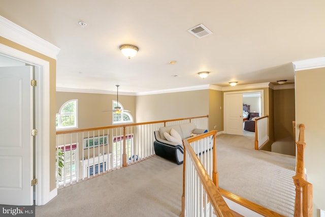 corridor featuring carpet, ornamental molding, an upstairs landing, and baseboards
