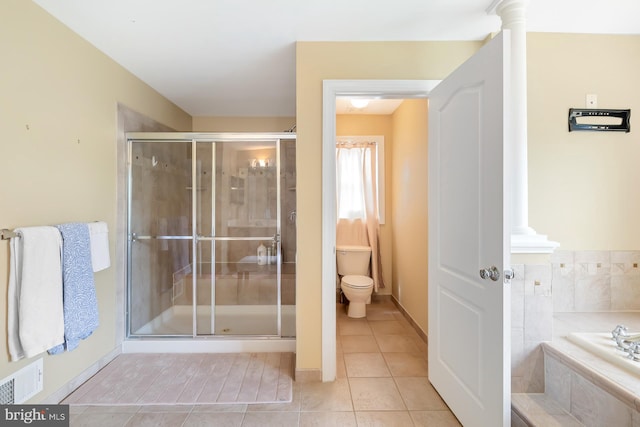 bathroom with a shower stall, toilet, tile patterned floors, a garden tub, and baseboards