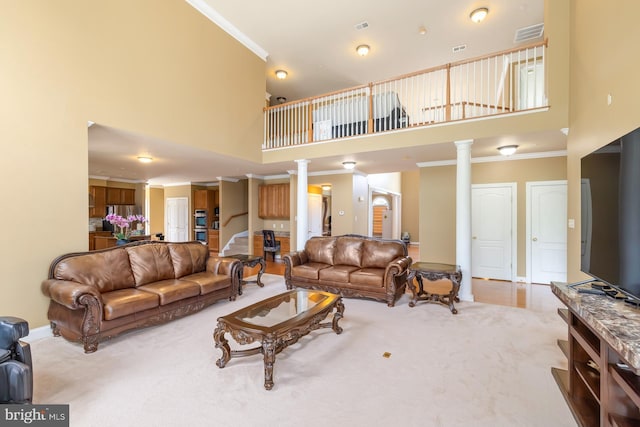 living room with a high ceiling, decorative columns, carpet floors, crown molding, and baseboards