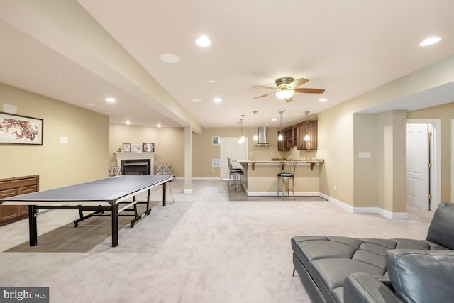 recreation room with ceiling fan, recessed lighting, a fireplace, baseboards, and light colored carpet