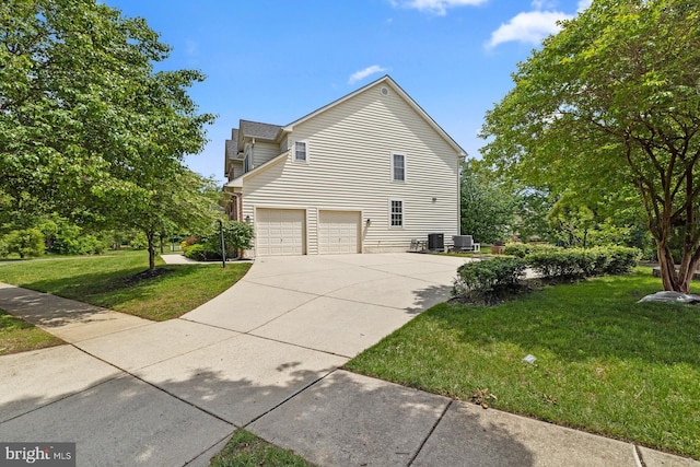 view of home's exterior with a garage, concrete driveway, a yard, and cooling unit