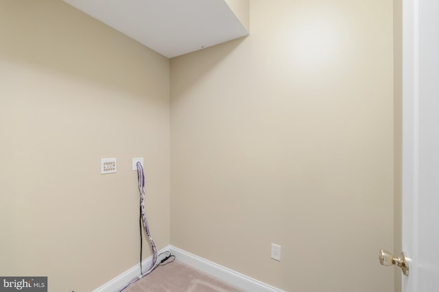laundry area featuring baseboards and light colored carpet