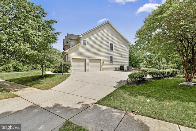 view of home's exterior featuring driveway, an attached garage, a lawn, and central AC
