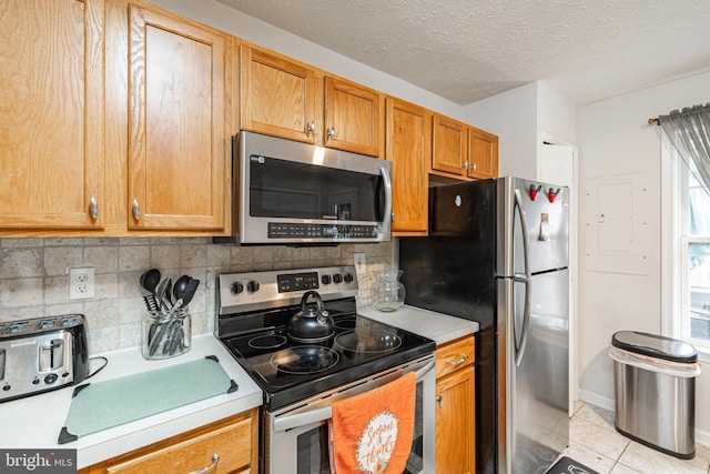 9910 Warwick Pl, Fredericksburg, VA 22408 - kitchen with appliances with stainless steel finishes, light countertops, tasteful backsplash, light tile patterned flooring, and a textured ceiling