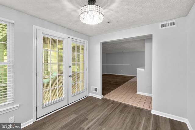 1476 Greenbriar Cir Unit 1-1476, Pikesville, MD 21208 - unfurnished dining area featuring french doors, dark wood finished floors, a chandelier, a textured ceiling, and baseboards