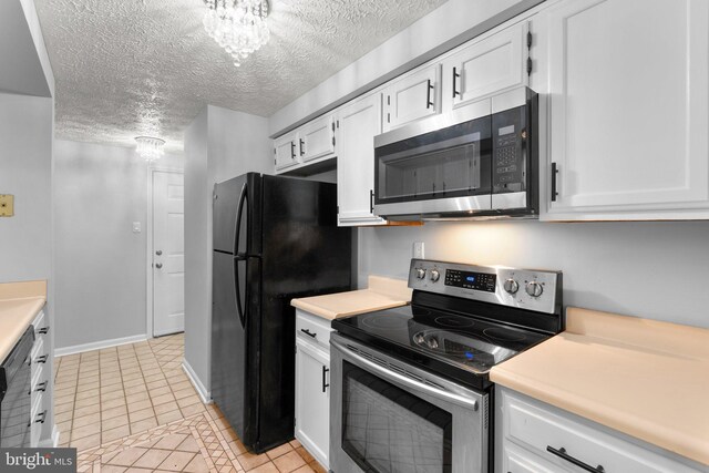 1476 Greenbriar Cir Unit 1-1476, Pikesville, MD 21208 - kitchen featuring appliances with stainless steel finishes, a chandelier, light tile patterned floors, white cabinetry, and a textured ceiling