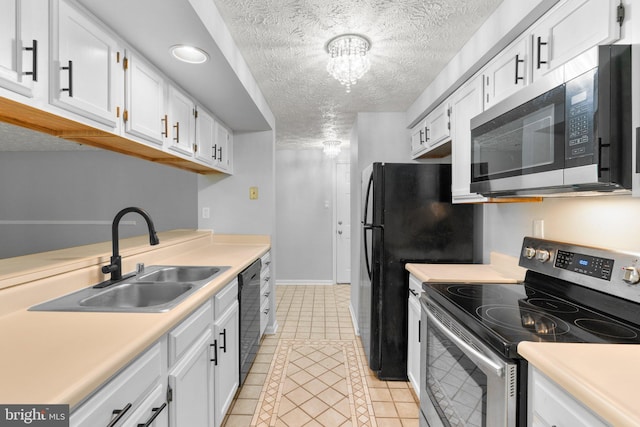 1476 Greenbriar Cir Unit 1-1476, Pikesville, MD 21208 - kitchen featuring appliances with stainless steel finishes, light tile patterned flooring, a textured ceiling, a sink, and white cabinetry