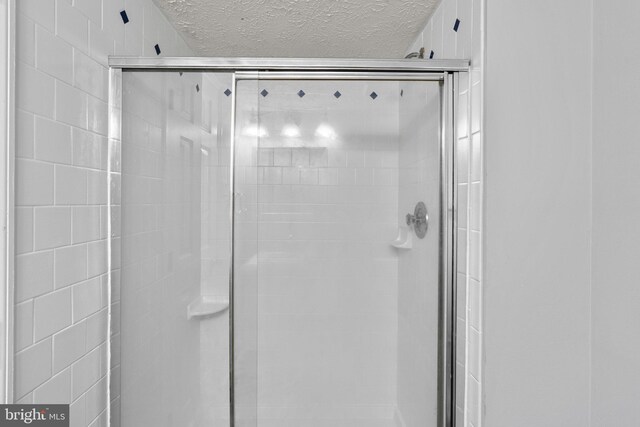 1476 Greenbriar Cir Unit 1-1476, Pikesville, MD 21208 - full bath featuring a textured ceiling and a stall shower