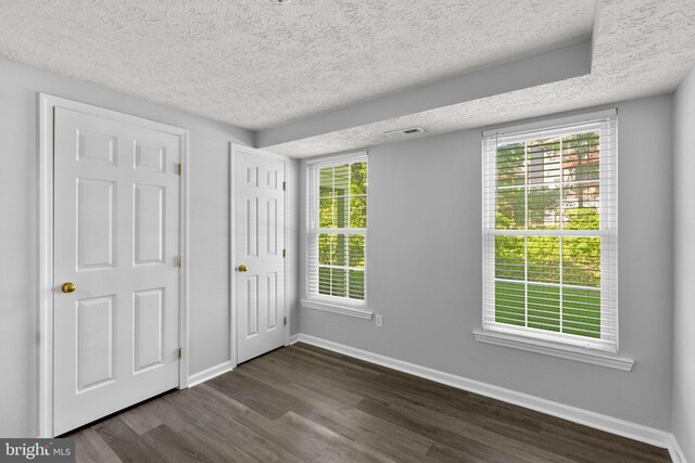 1476 Greenbriar Cir Unit 1-1476, Pikesville, MD 21208 - unfurnished bedroom featuring dark wood finished floors, baseboards, and a textured ceiling