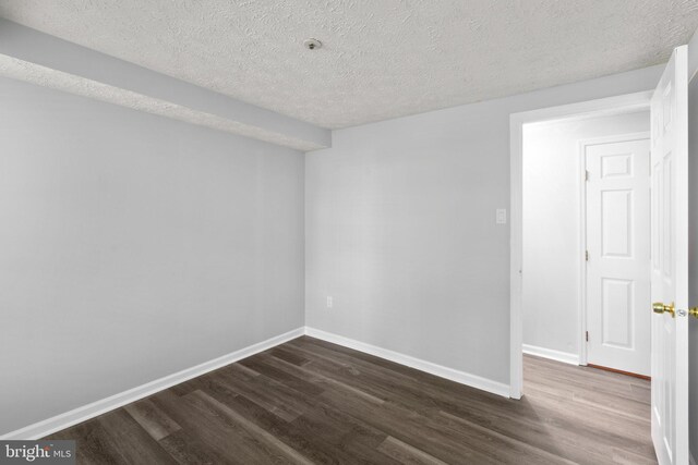 1476 Greenbriar Cir Unit 1-1476, Pikesville, MD 21208 - spare room with dark wood-style flooring, baseboards, and a textured ceiling