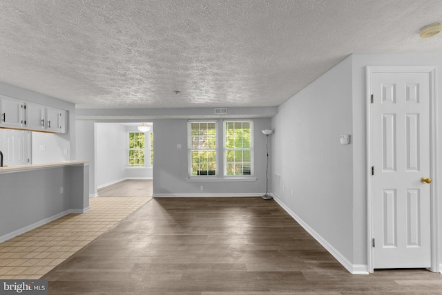 1476 Greenbriar Cir Unit 1-1476, Pikesville, MD 21208 - unfurnished living room with a textured ceiling, wood finished floors, and baseboards