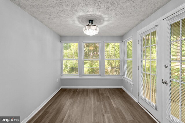 1476 Greenbriar Cir Unit 1-1476, Pikesville, MD 21208 - unfurnished sunroom with french doors, baseboards, wood finished floors, a chandelier, and a textured ceiling