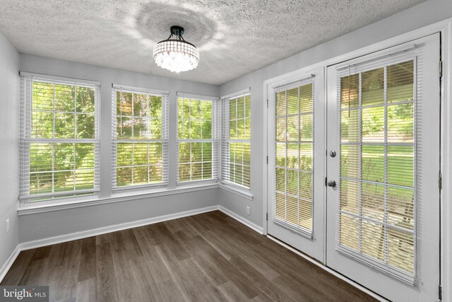 1476 Greenbriar Cir Unit 1-1476, Pikesville, MD 21208 - unfurnished sunroom featuring french doors, baseboards, wood finished floors, plenty of natural light, and a textured ceiling