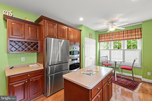 kitchen featuring appliances with stainless steel finishes, light countertops, ceiling fan, light wood-type flooring, and recessed lighting