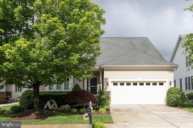 view of front of home featuring concrete driveway, an attached garage, stucco siding, and roof with shingles