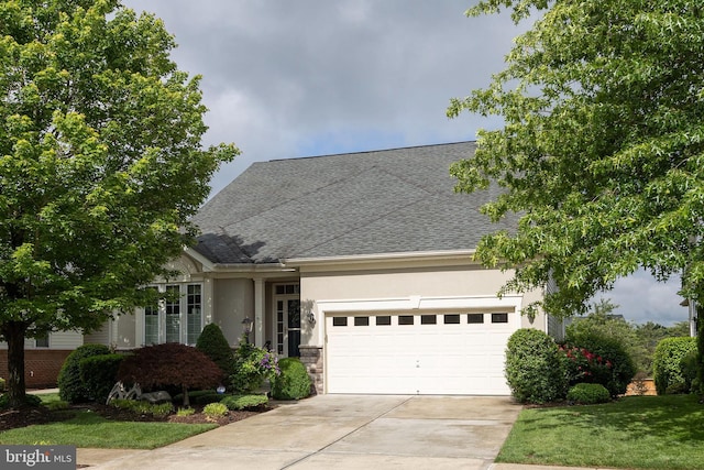 view of front of property featuring a shingled roof, concrete driveway, an attached garage, stucco siding, and a front yard