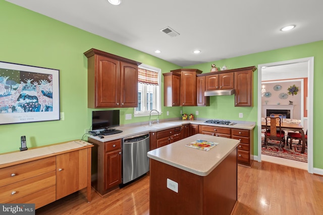 kitchen with a sink, stainless steel dishwasher, light countertops, light wood-type flooring, and recessed lighting