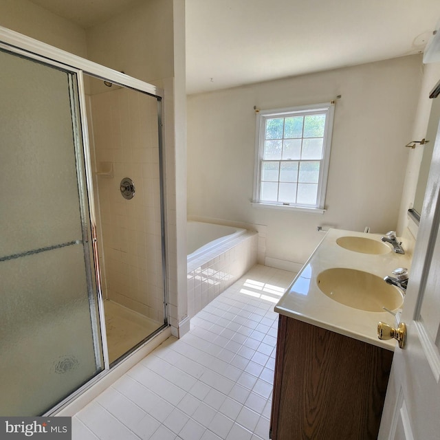 full bath featuring a sink, tile patterned floors, a stall shower, and a garden tub