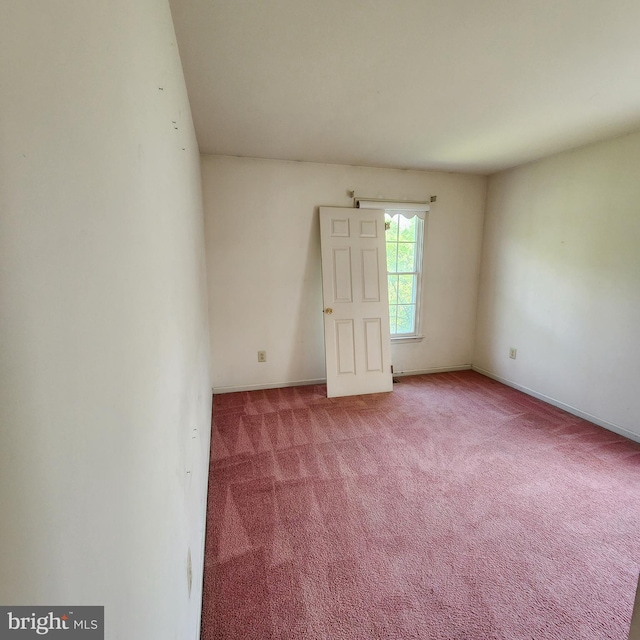 carpeted spare room featuring baseboards