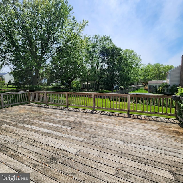 wooden deck featuring a lawn