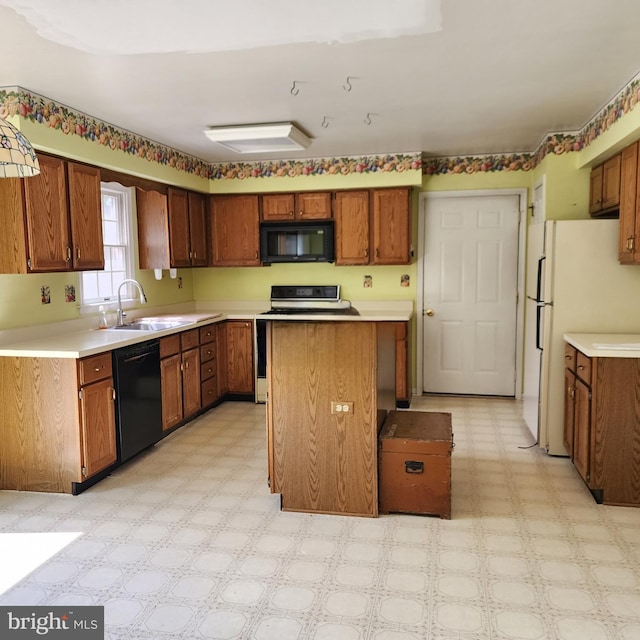 kitchen with black appliances, light flooring, a sink, light countertops, and brown cabinetry