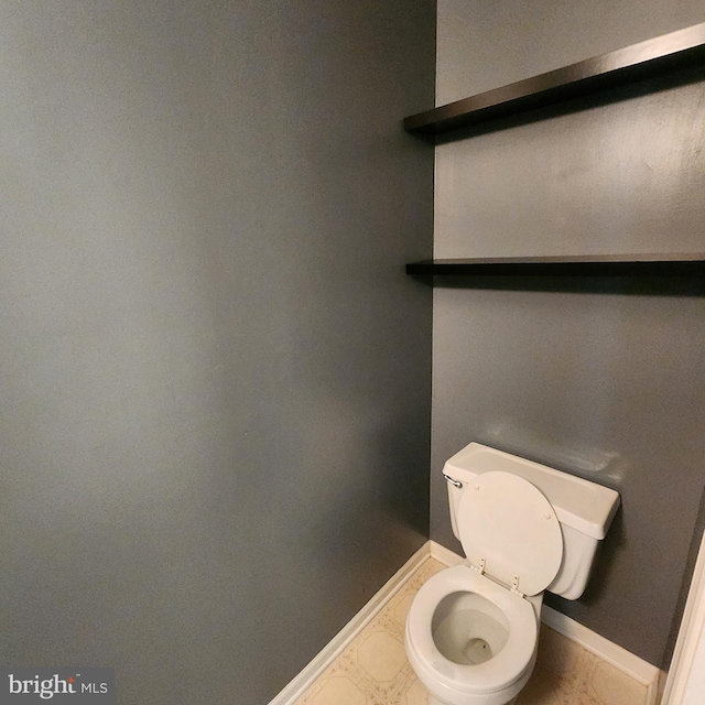 bathroom featuring baseboards and toilet