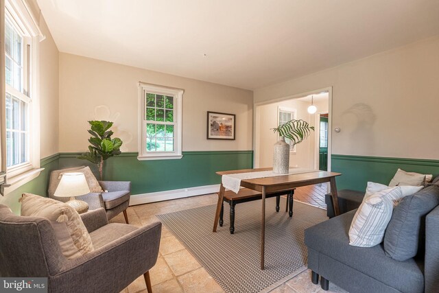 office area with a baseboard heating unit and a wainscoted wall