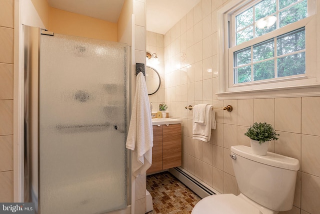 full bath featuring a baseboard heating unit, tile walls, vanity, a stall shower, and toilet