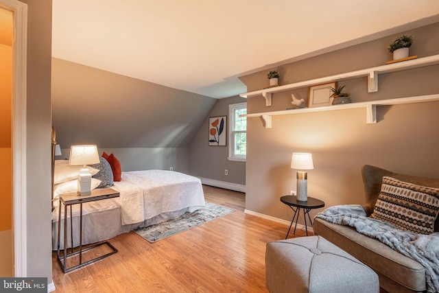 bedroom with baseboards, lofted ceiling, wood finished floors, and a baseboard radiator