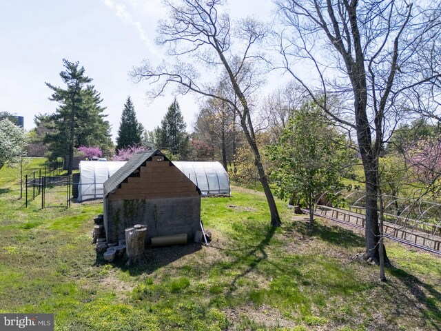 view of yard with fence and an outdoor structure