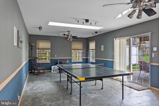 recreation room with ceiling fan, healthy amount of natural light, baseboards, and a skylight