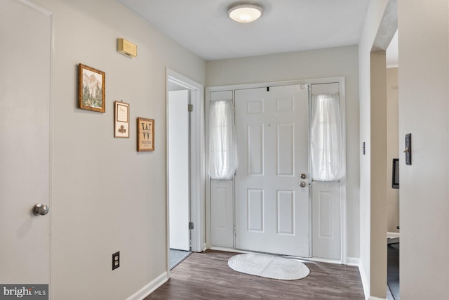 foyer entrance with wood finished floors and baseboards