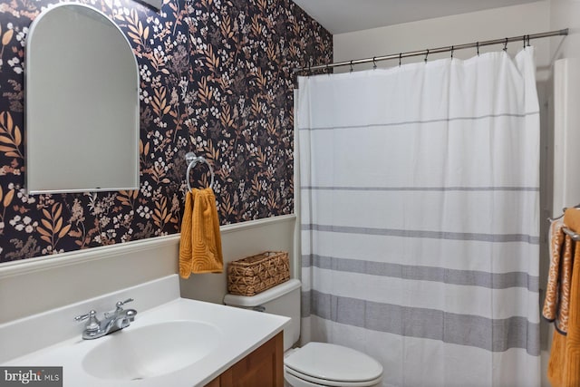 full bathroom featuring wallpapered walls, vanity, toilet, a shower with curtain, and a wainscoted wall