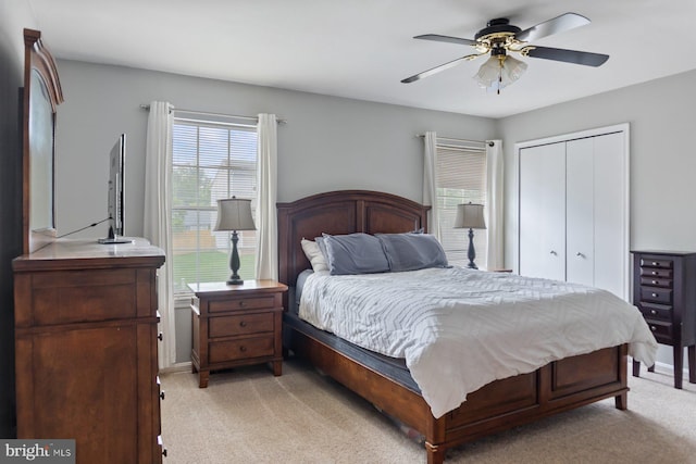 bedroom featuring light carpet, a closet, and ceiling fan