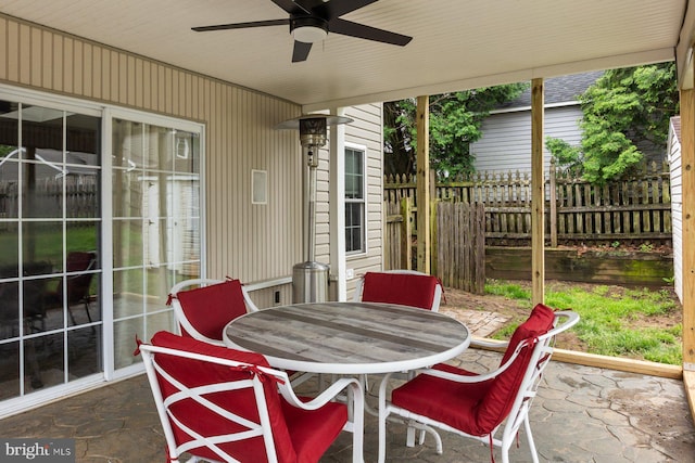 sunroom / solarium featuring ceiling fan and outdoor dining space
