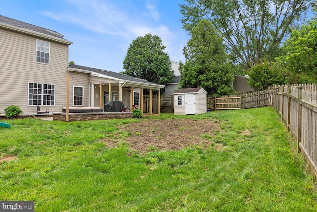 view of yard featuring a shed, an outdoor structure, and a patio area