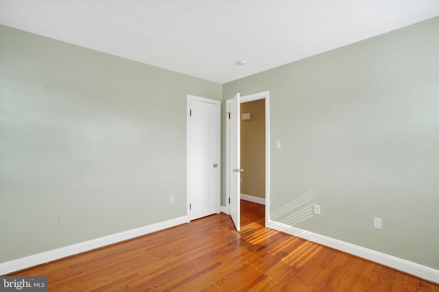 empty room featuring wood finished floors and baseboards