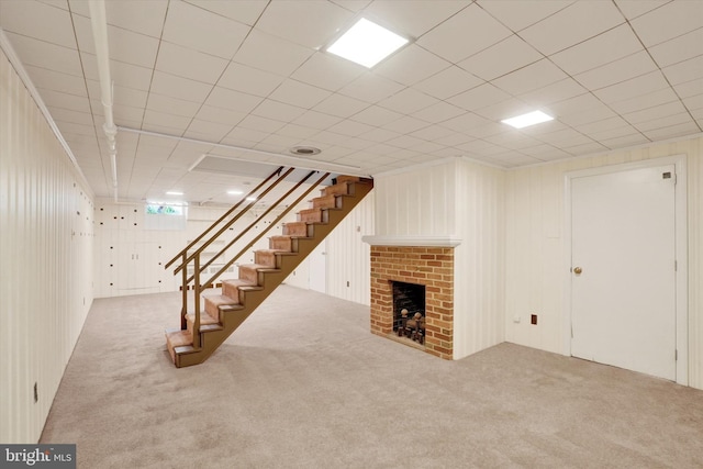 finished basement with stairs, carpet floors, and a fireplace