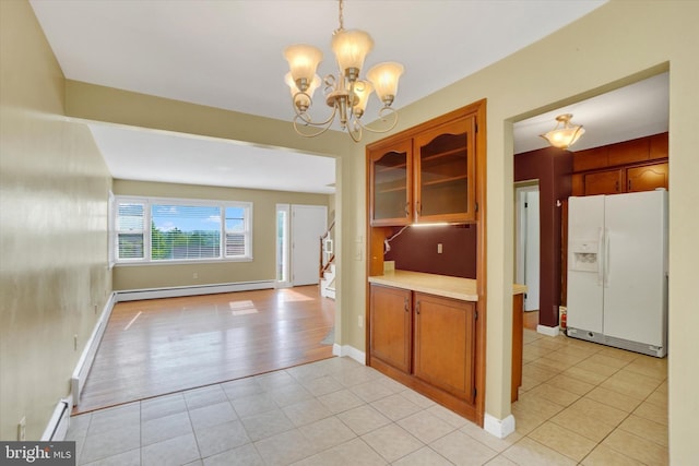 kitchen featuring white fridge with ice dispenser, baseboard heating, a chandelier, light tile patterned floors, and light countertops
