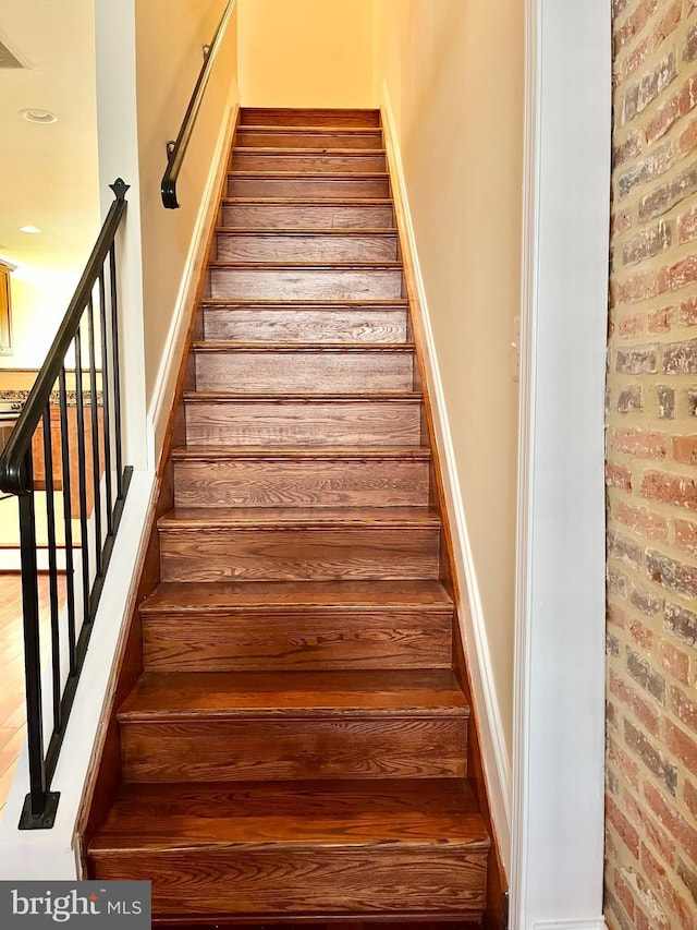 staircase with brick wall