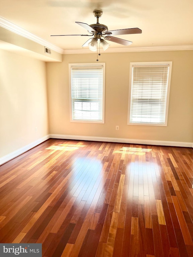 unfurnished room with wood-type flooring, a ceiling fan, crown molding, and baseboards